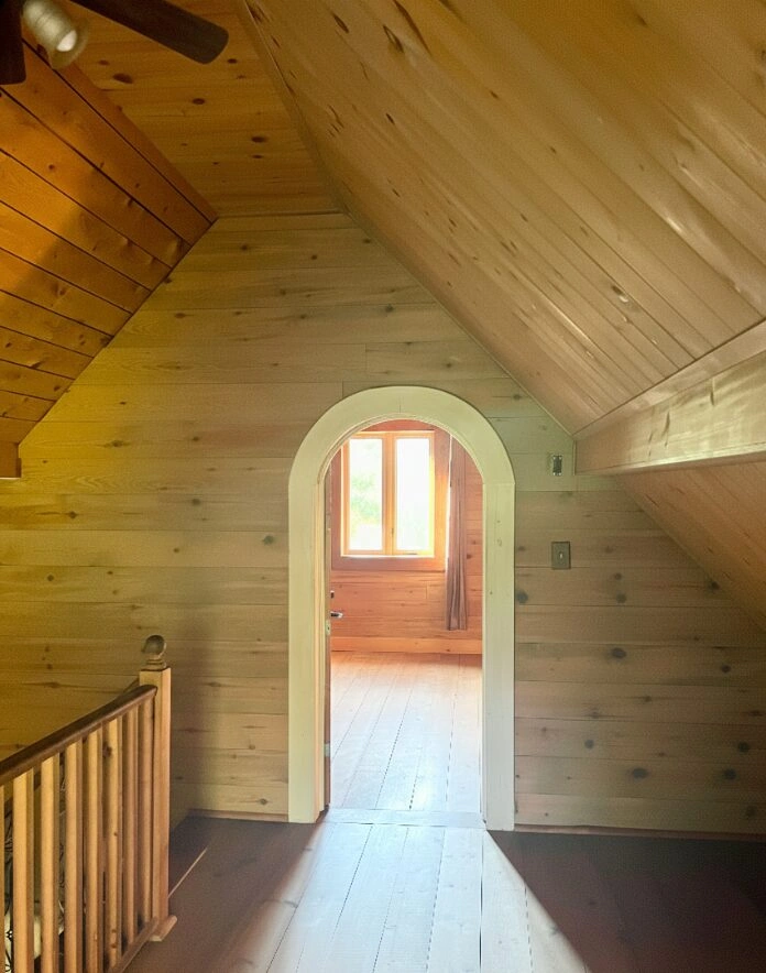 Mezzanine avec murs en pin et entrée voûtée