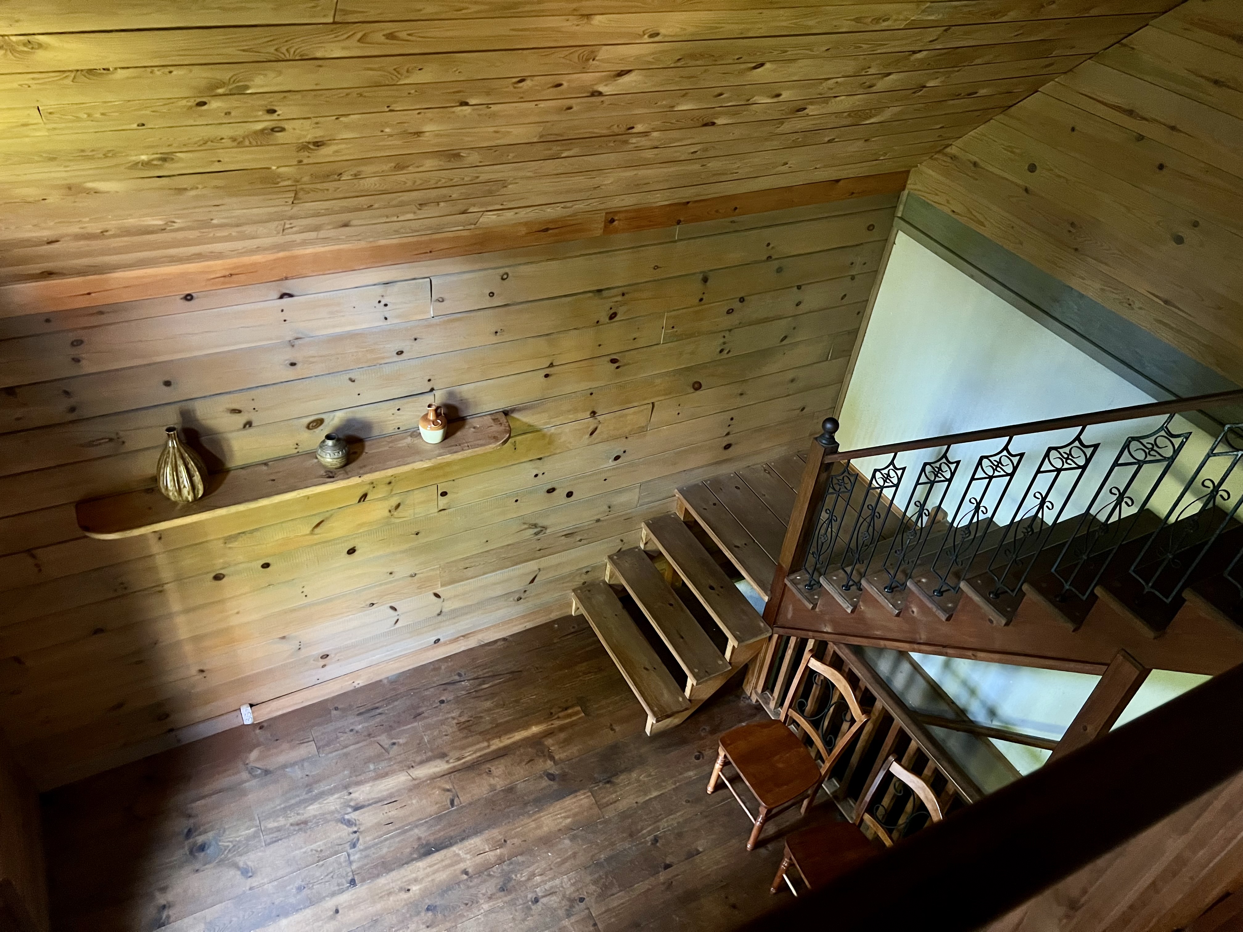 View from loft over staircase and wood panel wall